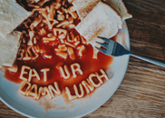 Plate of spaghetti alphabet spelling out eat Your Damn Lunch
