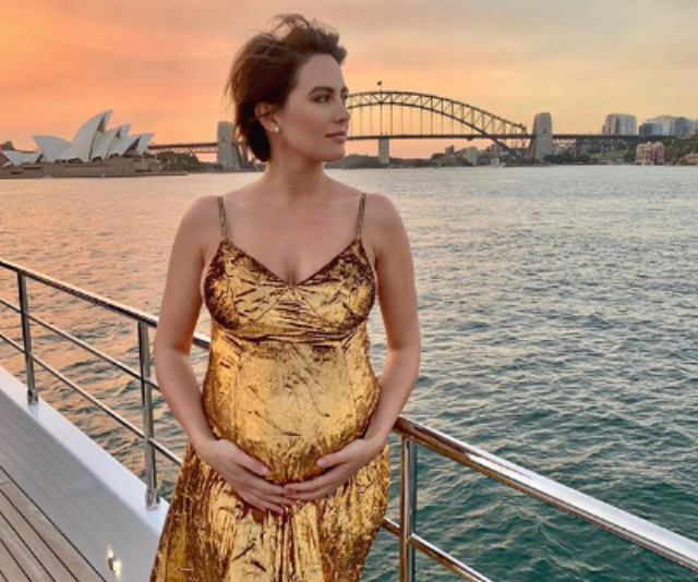 Pregnant Jesinta Franklin wearing gold dress at sunset in fron of the Harbour Bridge