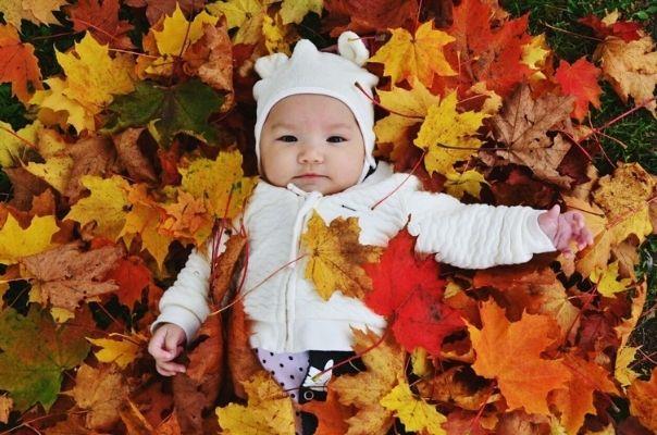 Baby girl in Autumn leaves